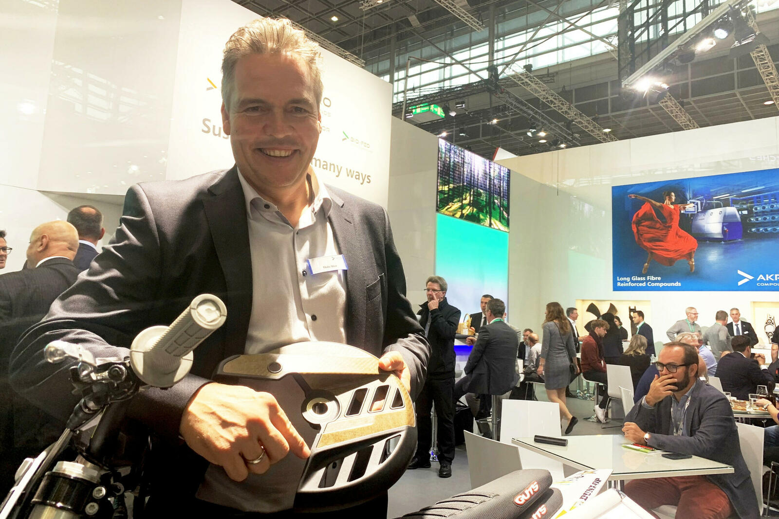 Thilo Stier, Global Sales Director & Innovation Manager bei Akro-Plastic, zeigt den Bremsscheibenschutz einer neuen Enduro aus dem Hause KTM. Das Bauteil besteht aus Naturfaser-Verbundkunststoff umspritzt mit Bio-PA-Compound.