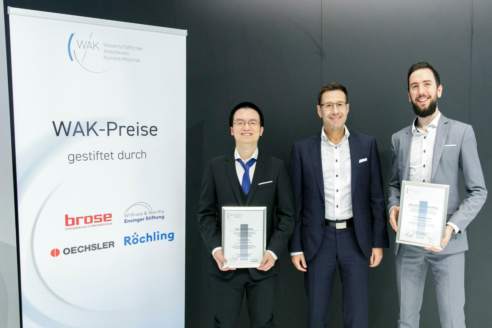 Tianchen Hong (l.) und Sebastian Kamerling (r.) haben die Auszeichnungen für ihre Abschlussarbeiten in der Kunststoff-Forschung im Rahmen der K2022 in Düsseldorf entgegengenommen. In der Mitte ihr Betreuer Alois K. Schlarb. 