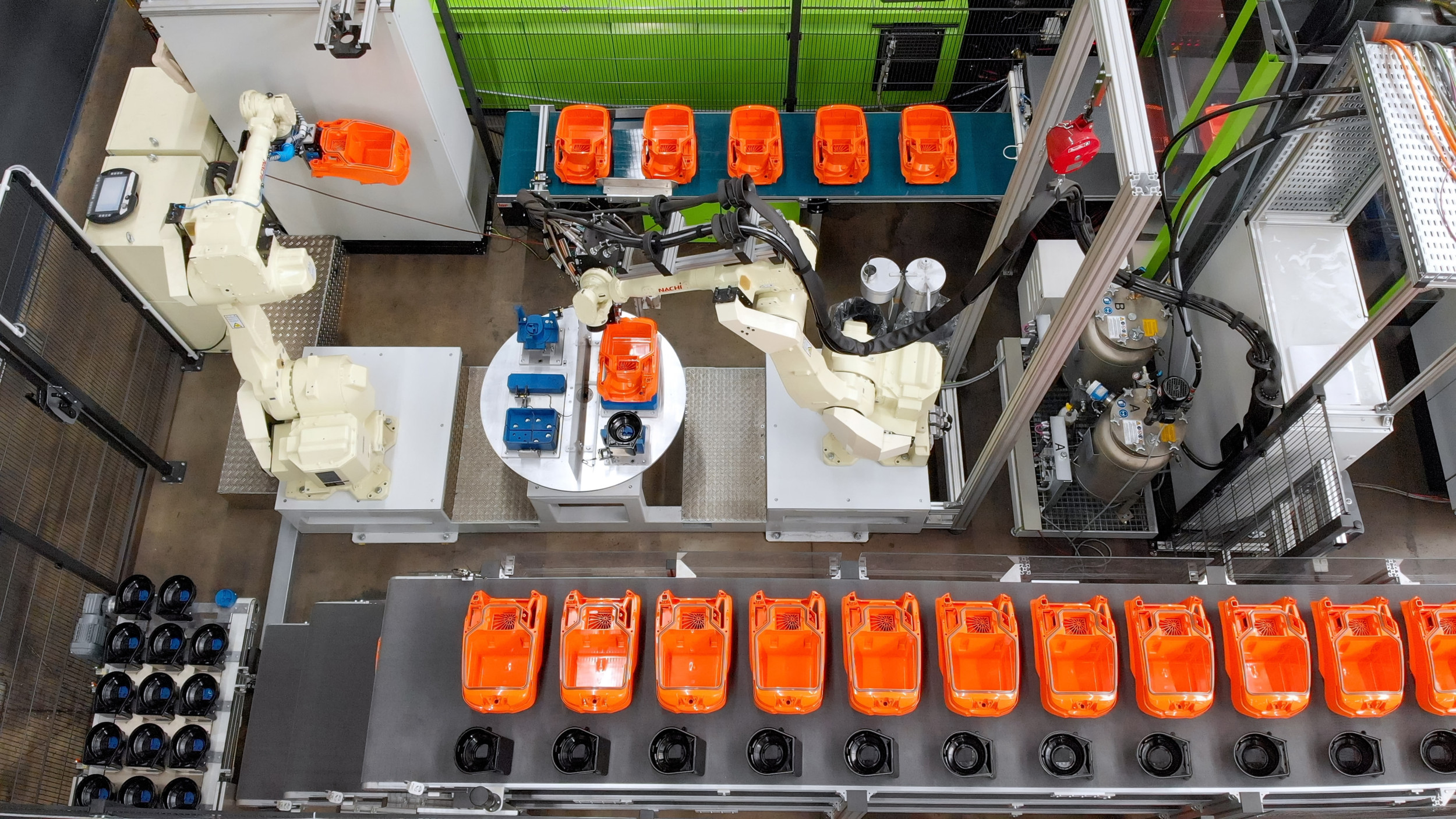 Der Sechsachs-Roboter legt das Staubsauger- und Motortopfgehäuse für den Dosierauftrag in einem Schritt auf den Rundtakttisch-Teileaufnahmen ab. 